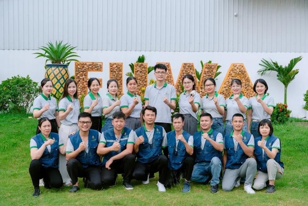 Das FUWA3E-Produktionsteam vor dem Werksschild in Thanh Hóa